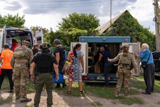 La police et les sciences médicales aident les gens à passer des voitures blindées aux ambulances du village de Yaroba